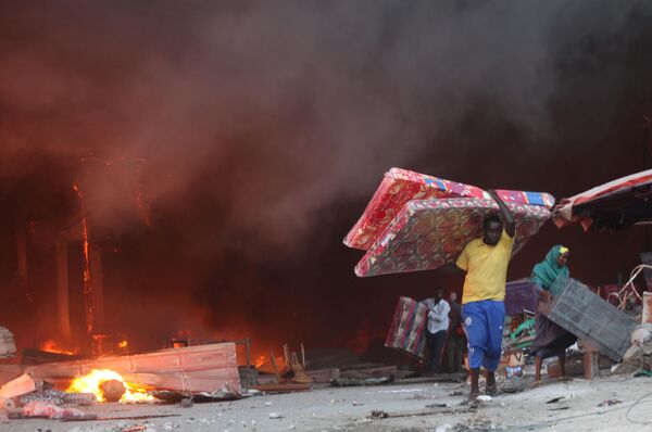 التجار الصوماليون يهربون بأشيائهم من متجر باكارا في مقديشو27 فبراير/ شباط 2017 - سبوتنيك عربي