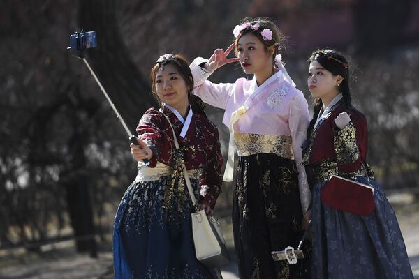 فتيات في سيؤول في زي تقليدي تلتقطن صور سيلفي من أمام قصر تشانغدوك في كوريا الجنوبية - سبوتنيك عربي