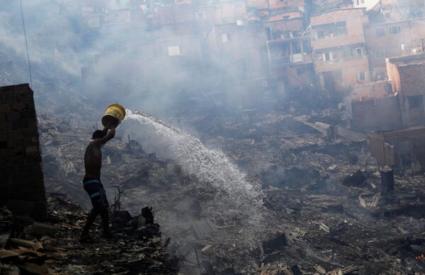 مواطن يطفئ حريقا في سان باولو، البرازيل 1 مارس/ آذار 2017 - سبوتنيك عربي