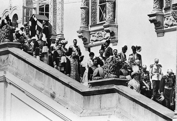 الإمبراطور الروسي نيكولاي الثاني والإمبراطورة ألكسندرا فيودوروفنا (أسفل يمين الصورة) يخرجون من غرفة غرانوفيتايا إلى الشرفة الحمراء خلال مراسم الاحتفال بالذكرى الـ300 لتولي سلالة رومانوف الحكم، عام 1913 - سبوتنيك عربي