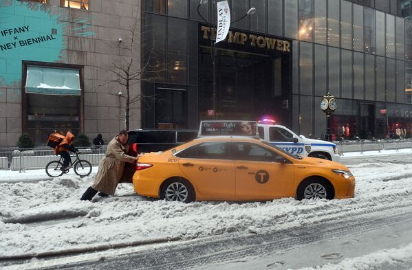 راكب سيارة أجرة في مدينة نيويورك يحاول دفع السيارة من مكانها، نيويورك 14 مارس/ آذار 2017 - سبوتنيك عربي