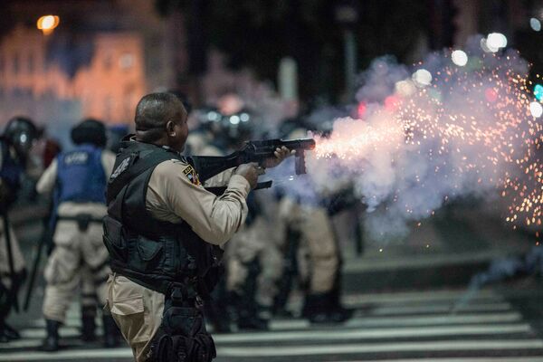 عناصر الشرطة البرازيلية يطلقون الرصاص المطاطي على المتظاهرين خلال اضراب عام، احتجاجا على إدخال التغيير والإصلاح في مشروع قانون نظام الرعاية الاجتماعية، في ريو دي جانيرو، البرازيل 15 مارس/ آذار 2017 - سبوتنيك عربي