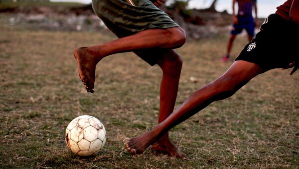 كوبيون يلعبون كرة القدم في ملعب للكرة بمدينة باراكوا، كوبا - سبوتنيك عربي