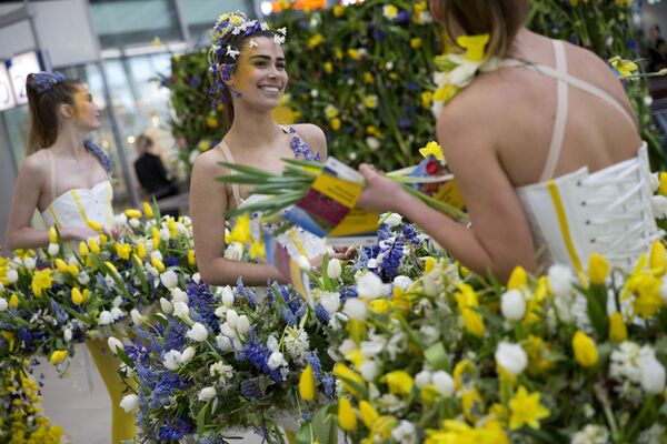 عارضات أزياء يرتدين أزياء مصنوعة من الأزهار الربيعية بمحطة القطار المركزية بمدينة أوترخت، هولندا 29 مارس/ آذار 2017 - سبوتنيك عربي