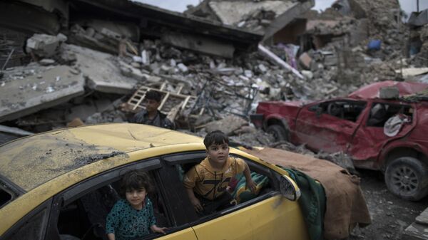 أطفال يلعبون داخل سيارة دمرت خلال المواجهات الحامية التي دارت بين قوات الأمن العراقية وتنظيم داعش في الجانب الغربي من الموصل، العراق 1 أبريل/ نيسان 2017 - سبوتنيك عربي