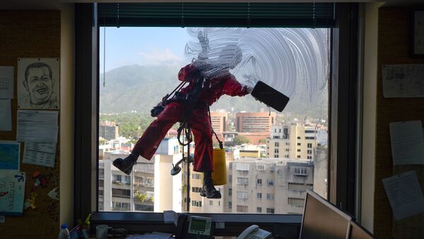عامل نظافة يقوم بتنظيف نوافذ مبنى في كاراكاس، فنزويلا 5 أبريل/ نيسان 2017 - سبوتنيك عربي