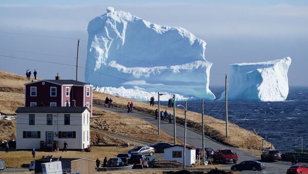 مواطنون كنديون يشاهدون عبور أول جبل جليدي يمر بمنطقة الساحل الجنوبي بالقرب من منطقة  فيريلاند نيوفاوندلاند، كندا 16 أبريل/ نيسان 2017 - سبوتنيك عربي
