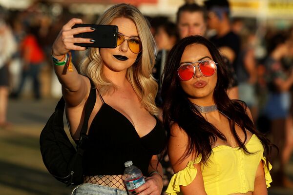 فتاتان تلتقطان صورة سيلفي على خلفية مهرجان الموسيقى والفن كوتشيللا في إنديو، كاليفورنيا، الولايات المتحدة 16 أبريل/ نيسان 2017 - سبوتنيك عربي