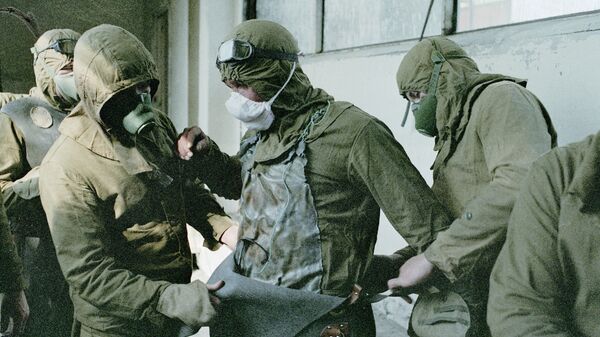 كارثة تشيرنوبيل - أشخاص يرتدون زيا واقيا قبل العمل على إزالة الأجزاء التالفة من سقف المفاعل الذري لمحطة تشيرنوبيل - سبوتنيك عربي