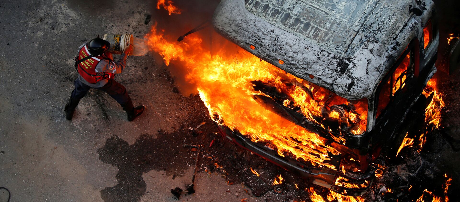إطفاء حريق اندلع في سيارة خلال احتجاجات عارمة ضد حكومة الرئيس نيكولاس مودورو في كاراكاس، فنزويلا 24 أبريل/ نيسان 2017 - سبوتنيك عربي, 1920, 09.12.2019