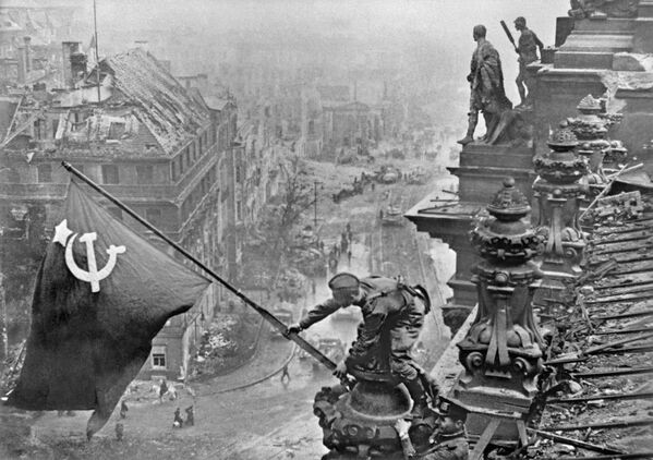 رفع راية النصر - العلم الأحمر - فوق مبنى الرايخستاغ بمدينة برلين، مايو/ آيار 1945 - سبوتنيك عربي
