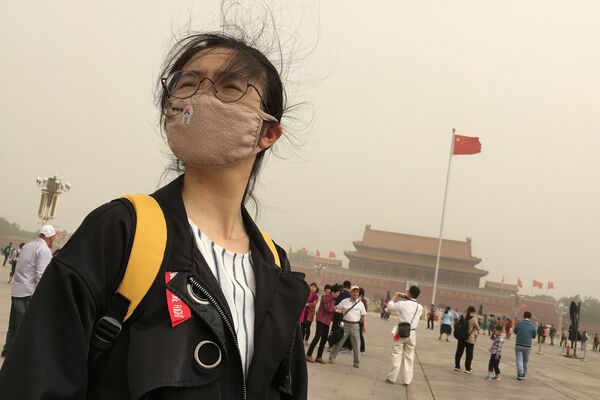 فتاة تزور ساحة تيانامين بينما تضرب عاصفة  رملية (غبار) في بكين، الصين 4 مايو/ أيار 2017 - سبوتنيك عربي