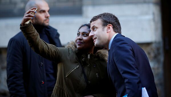 فتاة تلتقط صورة سيلفي مع المرشح للانتخابات الرئاسية الفرنسية إيمانويل ماكرون في باريس، فرنسا 2 مايو/ آيار 2017 - سبوتنيك عربي