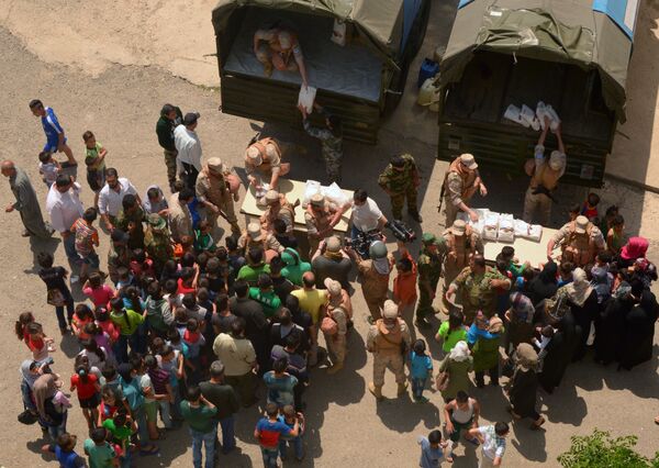 توزيع المساعدات الإنسانية في مخيم راس البسيط في اللاذقية - سبوتنيك عربي