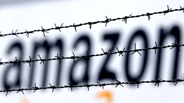 The internet trader Amazon logo is seen behind barbed wire at the company's logistic center in Rheinberg,Germany, Tuesday, Feb.19, 2013. - سبوتنيك عربي