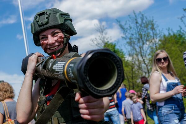 أحد الزوار يجرب الأسلحة العسكرية خلال معرض أودار كوروليا 2017 في بانيفيزيس، ليتوانيا - سبوتنيك عربي