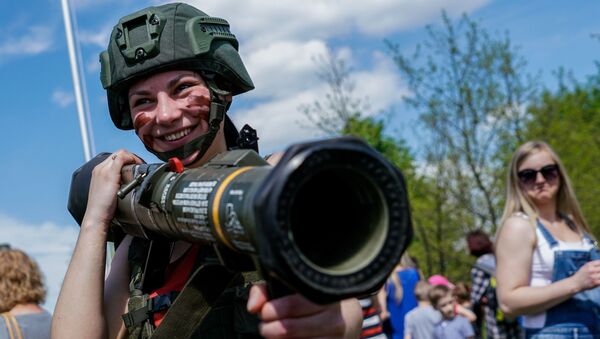 أحد الزوار يجرب الأسلحة العسكرية خلال معرض أودار كوروليا 2017 في بانيفيزيس، ليتوانيا - سبوتنيك عربي