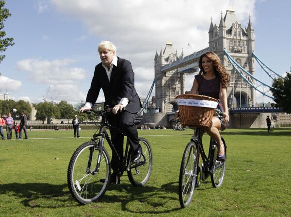 رئيس بلدية لندن (حينئذ) بوريس جونسون يركب دراجته برفقة كيلي بروك في لندن، 31 أغسطس/ آب 2010 - سبوتنيك عربي