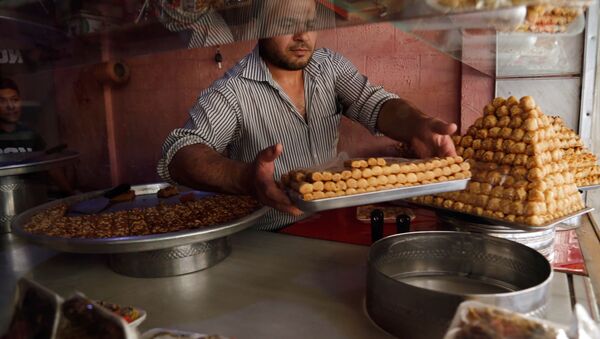 رجل يحضر الحلويات في مدينة الدوما، سوريا - سبوتنيك عربي