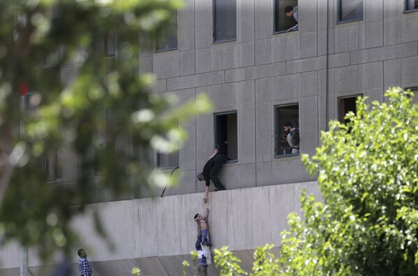 أشخاص يحاولون الهروب من مبنى البرلمان الإيراني في طهران، إيران 7 يونيو/ حزيران 2017 - سبوتنيك عربي