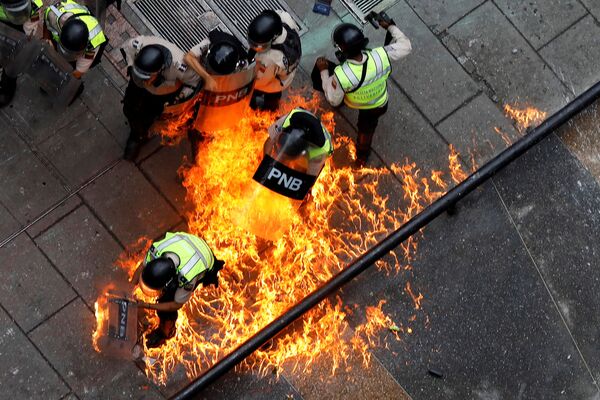 قذف عبوة نارية على عناصر شرطة الشغب وسط احتجاجات ضد حكومة الرئيس في العاصمة كاراكاس، فنزويلا 7 يونيو/ حزيران 2017 - سبوتنيك عربي