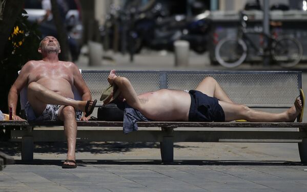 سكان برشلونة في أحد الأيام الحارة على شاطئ بارشلونيتا، حيث تم تحذير 50 محافظة حول ارتفاع الحرارة غير المعتاد في إسبانيا 13 يونيو/ حزيران 2017 - سبوتنيك عربي