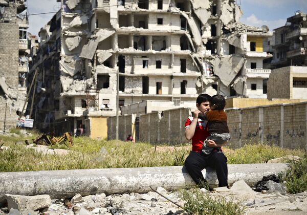 أطفال يلعبون في حي صلاح الدين المدمر في مدينة حلب السورية - سبوتنيك عربي