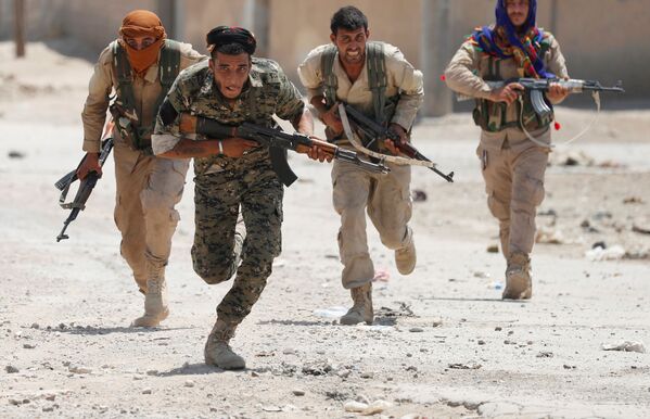 مقاتلون أكراد من وحدات حماية الشعب يجرون في أحد شوارع مدينة الرقة، سوريا 3 يوليو/ تموز 2017. - سبوتنيك عربي