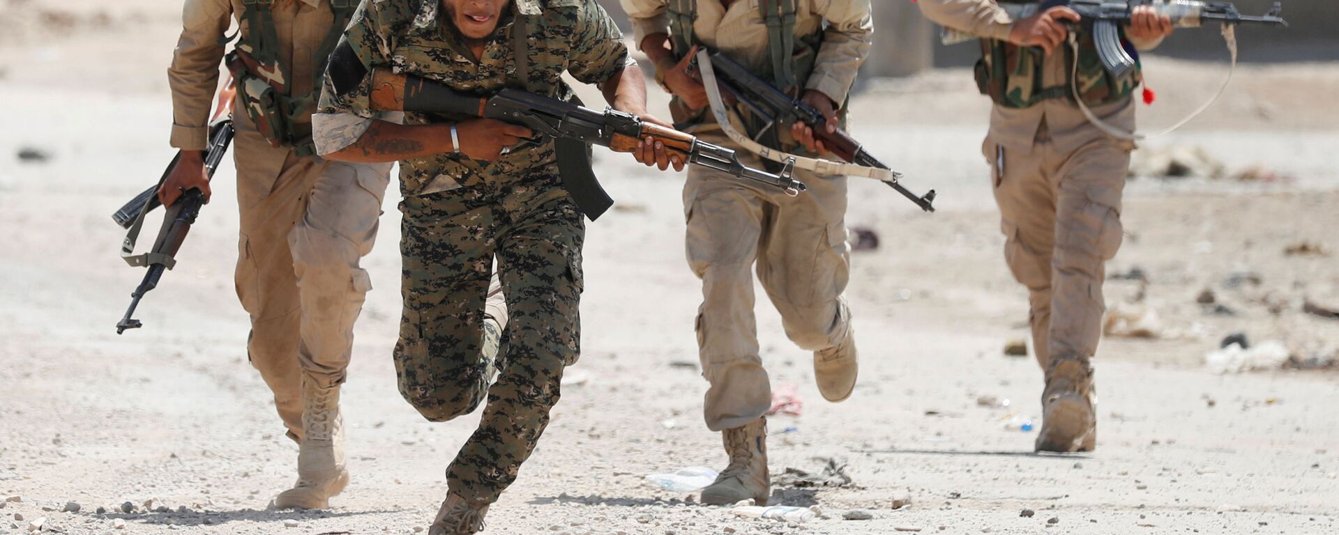 مقاتلون أكراد من وحدات حماية الشعب يجرون في إحدى شوارع مدينة الرقة، سوريا 3 يوليو / تموز 2017. - سبوتنيك عربي, 1920, 05.02.2022