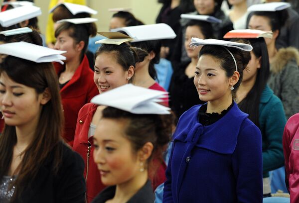 فتيات يافعات خلال التدريب على الوقوف والابتسامة قبل الوصول إلى المرحلة الأخيرة لاختيارهن في طاقم مضيفات طيران الخطوط الجوية الصينية - سبوتنيك عربي