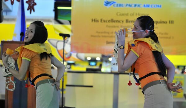 مضيفات الطيرات سيبو باسيفيك (Cebu Pacific) خلال عرض ارشادات سلامة الركاب على متن الطائرة، الفلبين - سبوتنيك عربي