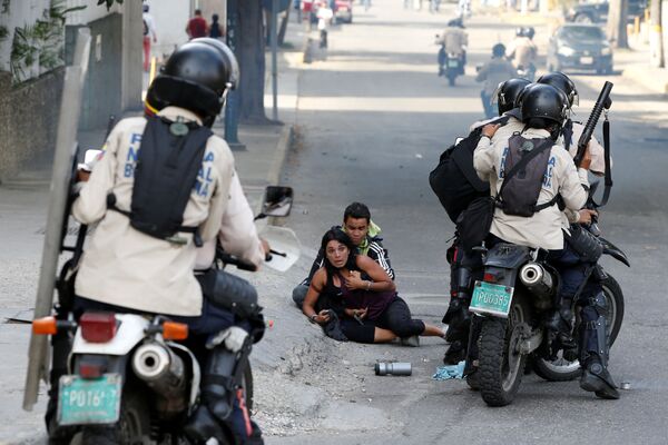 مصابان من أنصار المعارضة إثر استخدام الشرطة لرذاذ الفلفل في كاراكاس، فنزويلا، 9 يوليو/ تموز 2017 - سبوتنيك عربي