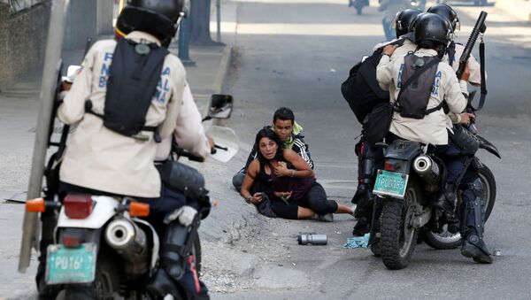 مصابان من أنصار المعارضة إثر استخدام الشرطة لرذاذ الفلفل في كاراكاس، فنزويلا 9 يوليو/ تموز 2017 - سبوتنيك عربي