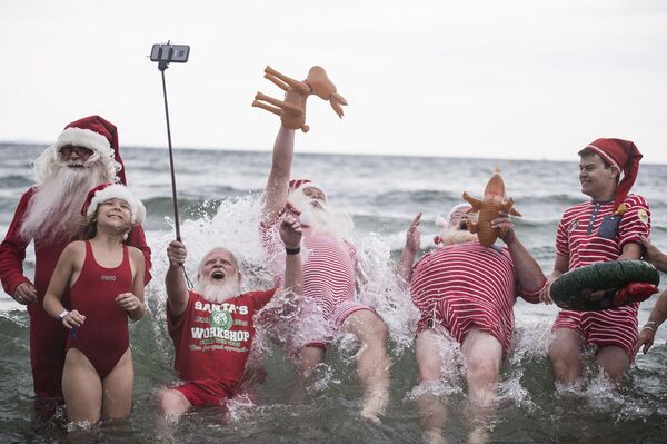 قفزة سانتا خلال التقاط صورة جماعية في الماء في متنزه ديريافسباكن في كلامبنبورغ، شمال كوبنهاغن في 25 يوليو/ تموز 2017 - سبوتنيك عربي