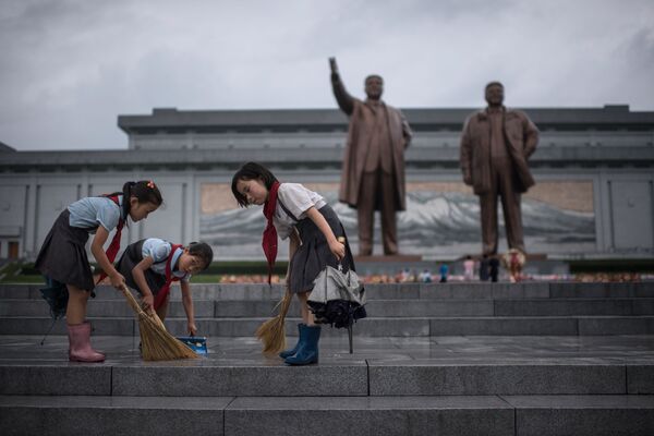 تلاميذ ينظفون الدرج الذي يقود إلى تماثيل الزعيمين الكوريين الشماليين الراحلين كيم إيل سونغ وكيم جونغ إيل، على تلة مانسو فى بيونغ يانغ، كوريا الشمالية فى 27 يوليو/ تموز 2017 صادف هذا اليوم إحياء الذكرى الـ 64 لتوقيع معاهدة الهدنة الكورية، وهو يوم نصر وعطلة رسمية - سبوتنيك عربي