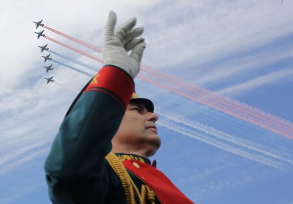 موسيقار لفرقة موسيقية عسكرية على خلفية طائرات حربية روسية ترسم ألوان علم روسيا في سماء مدينة سان بطرسبورغ، روسيا - سبوتنيك عربي