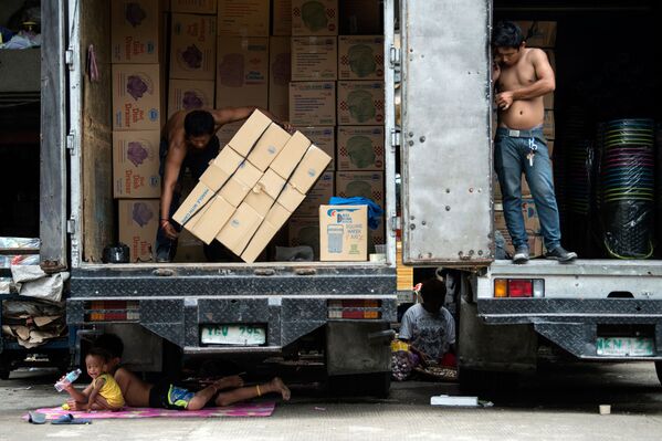 أطفال يستريحون تحت شاحنة نقل في مانيلا، 3 أغسطس/ آب 2017 - سبوتنيك عربي