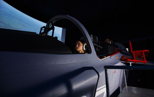 فتاة مرشحة للالتحاق بمعهد كراسنودار العالي للطيران العسكري خلال محاكاة لقمرة القيادة داخل الطائرة - سبوتنيك عربي