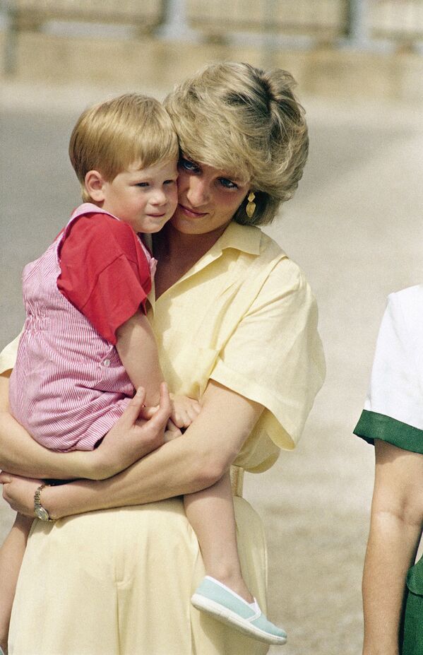 الأميرة ديانا تحمل ابنها هاري بين ذراعيها في إسبانيا، عام 1987 - سبوتنيك عربي