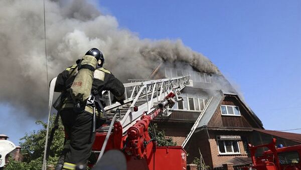 رجال إطفاء الحريق خلال إطفاء نيران اشتعلت في بيت للعجزة في قرية جيمتشوجينا في كراسنويارسك - سبوتنيك عربي