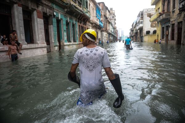 الكوبيون في شارع غمرته الفيضانات في هافانا يوم 10 سبتمبر/أيلول عام 2017، بعد أن ضرب إعصار إرما القاتل وسط كوبا يوم السبت. - سبوتنيك عربي