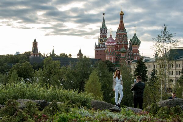 الزوار يلتقطون صورا في حديقة زارياديا على خلفية  برج سباسكايا من الكرملين، موسكو. واحتفلت كاتدرائية باسل بمناسبة عيد ميلاد الـ 870  لمدينة موسكو يوم 9 سبتمبر/أيلول 2017. - سبوتنيك عربي