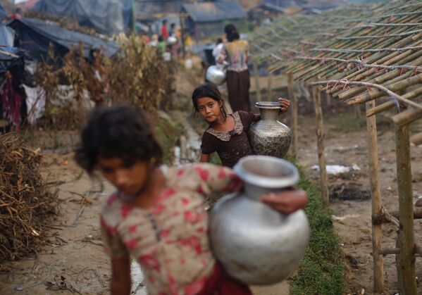 لاجئات الروهينغا يحملن خرامات معدنية بالماء في مخيم بالوخالي المؤقت للاجئين في كوكس بازار، بنغلاديش، في 13 سبتمبر/أيلول، 2017. - سبوتنيك عربي