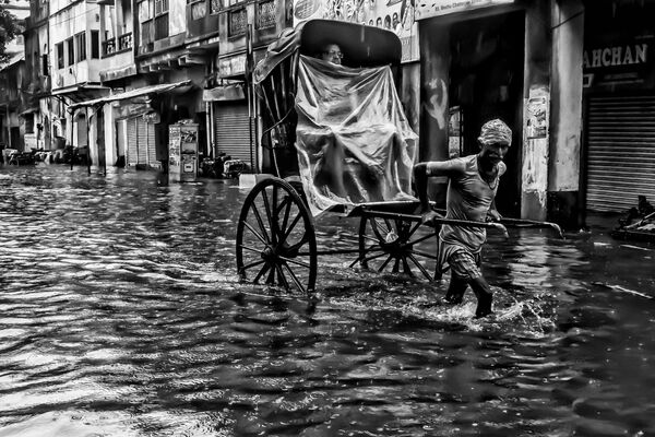 حياة المدينة تحت الأمطار، للمصور ديارشي موخرجي، الذي دخل في نهائيات مسابقة مصور الطقس لعام 2017 - سبوتنيك عربي