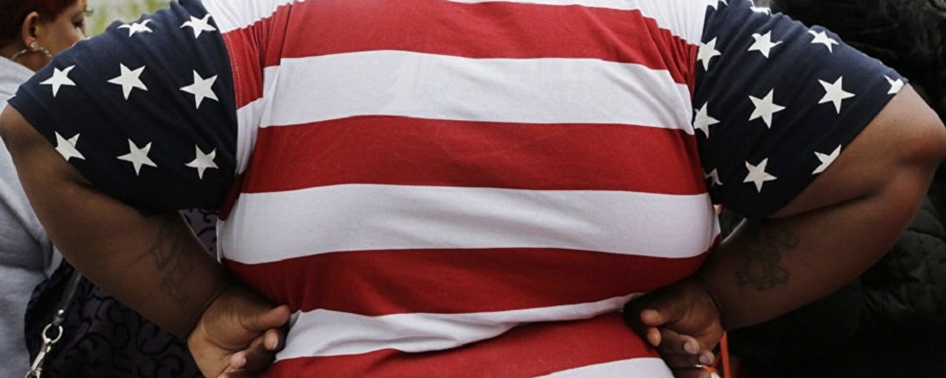 شخص مصاب بالسمنة يلبس رداء العلم الأمريكي  - سبوتنيك عربي, 1920, 27.03.2023