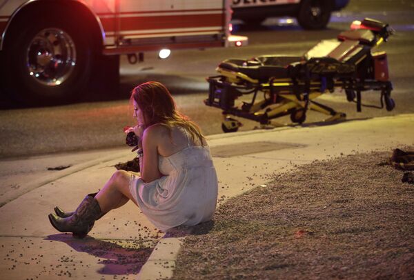فتاة تجلس على حافة طريق بعد حادث إطلاق نار في لاس فيغاس، الولايات المتحدة الأمريكية 2 أكتوبر/ تشرين الأول 2017 - سبوتنيك عربي
