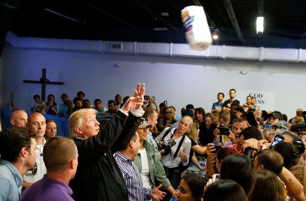 الرئيس دونالد ترامب يقذف بمناشف ورقية إلى حشد من المواطنبن المتضررين من إعصار ماريا، وذلك أثناء زيارته لكالغري شابل في سان خوان، بورتوريكو، الولايات المتحدة الأمريكية، 3 أكتوبر/ تشرين الأول 2017 - سبوتنيك عربي