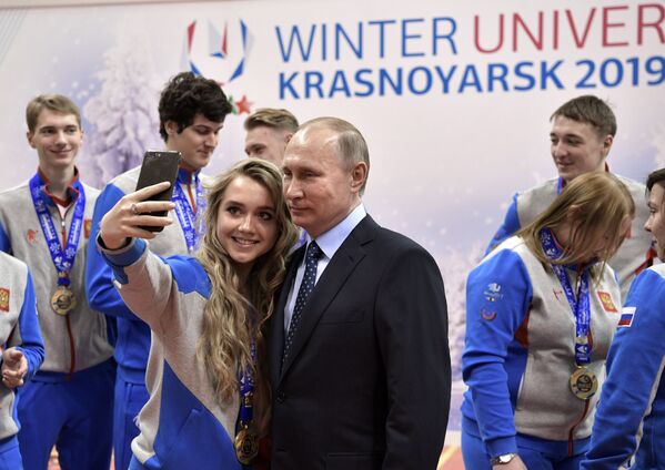 فتاة تلتقط صورة سيلفي مع الرئيس الروسي فلاديمير بوتين خلال زيارته للمسابقة الرياضية الدولية والوطنية بين الطلاب لعام 2017 في كراسنونيارسك، روسيا - سبوتنيك عربي