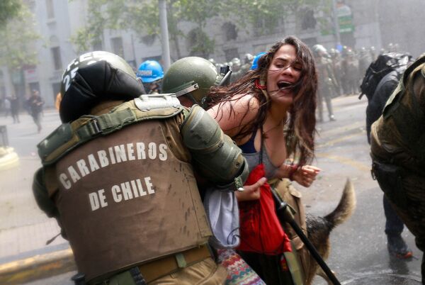 اشتباك المتظاهرين مع الشرطة خلال الاحتجاجات في يوم كولومبو في سانتياغو، تشيلي 9 أكتوبر/ تشرين الأول 2017 - سبوتنيك عربي