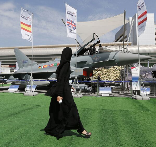 فتاة تسير على خلفية قاذفة Eurofighter Typhoon في المعرض العسكري IDEX  في الإمارات العربية المتحدة - سبوتنيك عربي